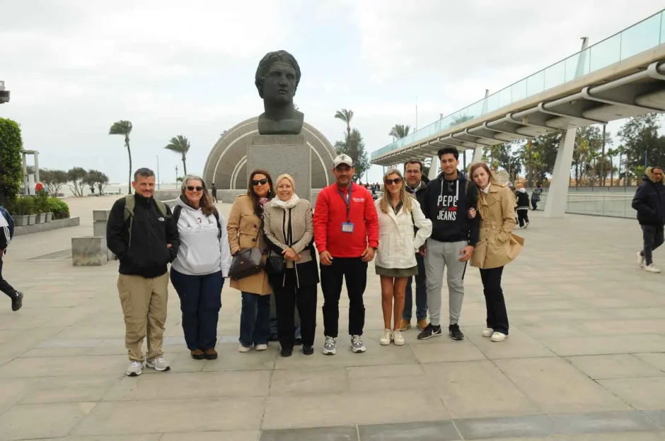 Alexandria & Nile Cruise Tour group with Ramses Tours posing by a statue during a city excursion in Egypt.