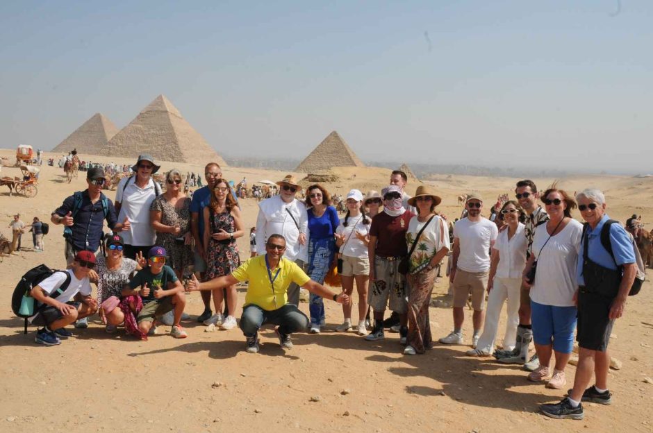 Happy tourists at the Giza Pyramids during a 4 Days Cairo & Luxor Egypt Tour Package, exploring ancient wonders.