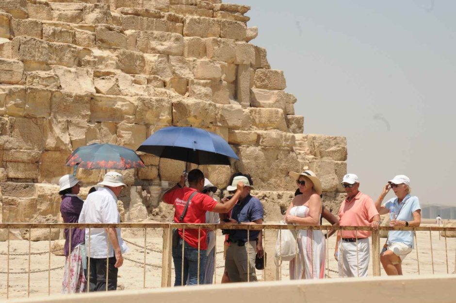Tourists explore ancient wonders during a Pyramids’ Egypt Tour, marveling at the massive stone structures in Giza.