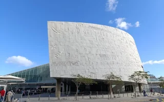 The modern Bibliotheca Alexandrina in Egypt, featuring a massive tilted stone facade engraved with characters from various world languages.