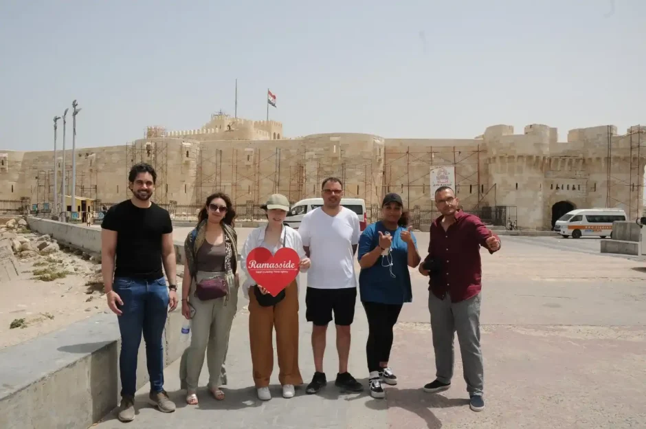 Tourists at Qaitbay Citadel, Alexandria. The 15th-century fortress and a van are in the background.