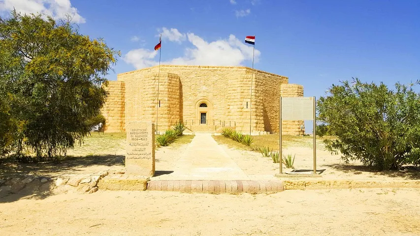 The solemn stone exterior of a World War II memorial building, often visited during historical excursions outside Alexandria.