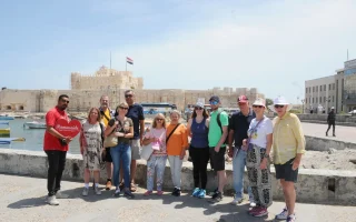 A happy tourist enjoying a full day tour in Alexandria Egypt at the historic Citadel of Qaitbay.