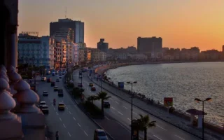 Sunset over Alexandria Corniche during an overnight , showing the Mediterranean coast, city skyline, and waterfront road in Egypt.