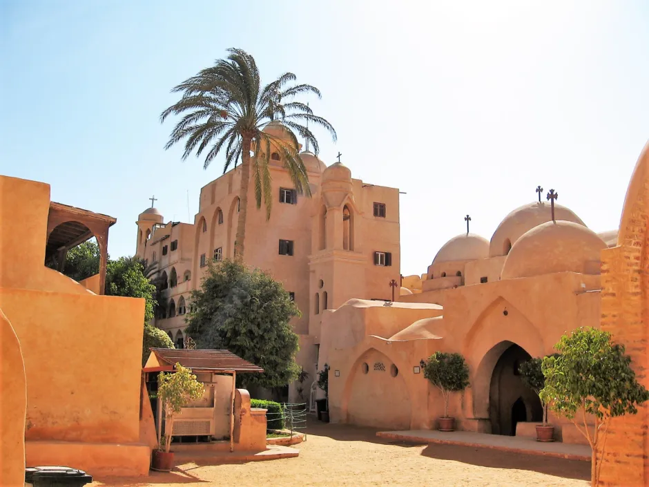 The peaceful desert courtyard and traditional domed architecture of an ancient Coptic Christian monastery.