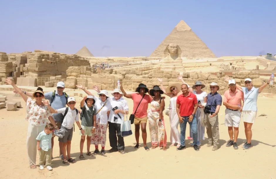 Tourists enjoying Egypt Vacation Packages in front of the Great Sphinx and Pyramids of Giza during a professional guided tour.